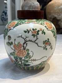 A pair of Chinese famille verte 'Floral' jars with wooden covers, 19th C.