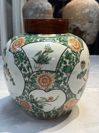 A pair of Chinese famille verte 'Floral' jars with wooden covers, 19th C.