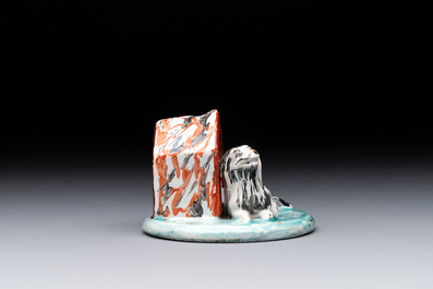 A rare polychrome Dutch Delft petit feu sculpture of a dog in front of its kennel, 18th C.