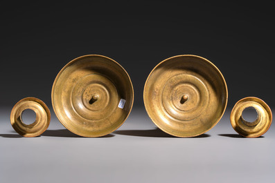 A pair of Empire parcel-gilt bronze candlesticks, early 19th C.