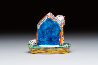 A rare polychrome Dutch Delft sculpture of a dog in front of its kennel, 18th C.