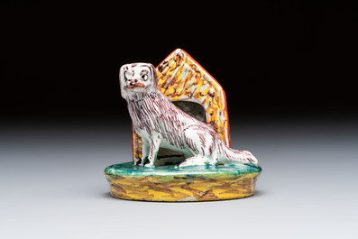 A rare polychrome Dutch Delft sculpture of a dog in front of its kennel, 18th C.