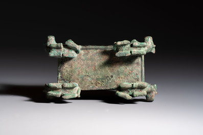A Chinese archaic bronze cosmetic box standing on four stylised buffalo-form feet, Lian 奩, Eastern Zhou/Spring and Autumn
