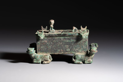 A Chinese archaic bronze cosmetic box standing on four stylised buffalo-form feet, Lian 奩, Eastern Zhou/Spring and Autumn