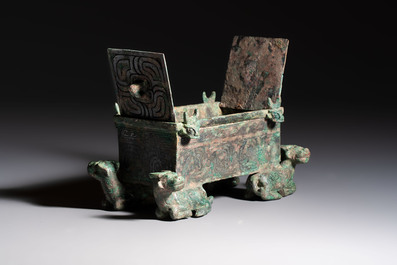 A Chinese archaic bronze cosmetic box standing on four stylised buffalo-form feet, Lian 奩, Eastern Zhou/Spring and Autumn
