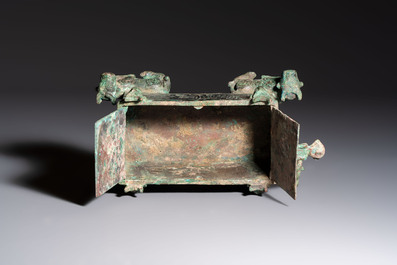A Chinese archaic bronze cosmetic box standing on four stylised buffalo-form feet, Lian 奩, Eastern Zhou/Spring and Autumn