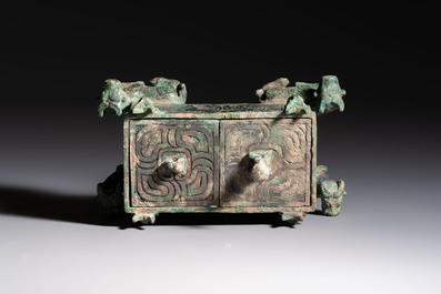 A Chinese archaic bronze cosmetic box standing on four stylised buffalo-form feet, Lian 奩, Eastern Zhou/Spring and Autumn