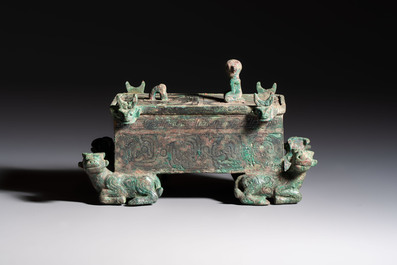 A Chinese archaic bronze cosmetic box standing on four stylised buffalo-form feet, Lian 奩, Eastern Zhou/Spring and Autumn