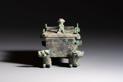 A Chinese archaic bronze cosmetic box standing on four stylised buffalo-form feet, Lian 奩, Eastern Zhou/Spring and Autumn