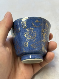 A pair of Chinese gilt-decorated powder-blue-ground 'Antiquities' cups and saucers, lingzhi mark, Kangxi
