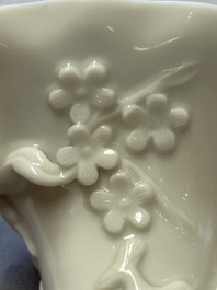 A Chinese Dehua blanc de Chine 'Dragon, Carp, Crane and Deer' libation cup, Kangxi