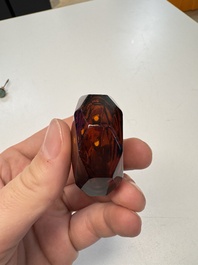 A Chinese facetted amber glass snuff bottle, 19th C.
