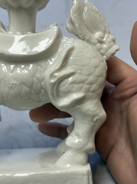 A Chinese Dehua blanc de Chine candlestick in the form a qilin, Kangxi