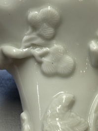 A Chinese Dehua blanc de Chine 'Dragon, Carp, Crane and Deer' libation cup, Kangxi