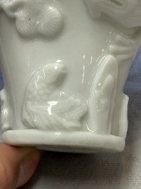 A Chinese Dehua blanc de Chine 'Dragon, Carp, Crane and Deer' libation cup, Kangxi