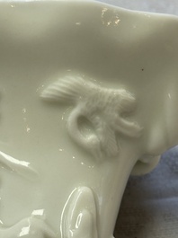 A Chinese Dehua blanc de Chine 'Dragon, Carp, Crane and Deer' libation cup, Kangxi