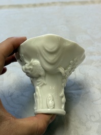 A Chinese Dehua blanc de Chine 'Dragon, Carp, Crane and Deer' libation cup, Kangxi