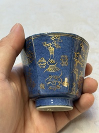 A pair of Chinese gilt-decorated powder-blue-ground 'Antiquities' cups and saucers, lingzhi mark, Kangxi
