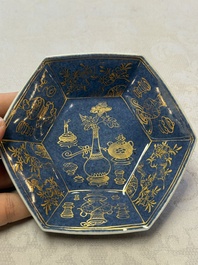A pair of Chinese gilt-decorated powder-blue-ground 'Antiquities' cups and saucers, lingzhi mark, Kangxi