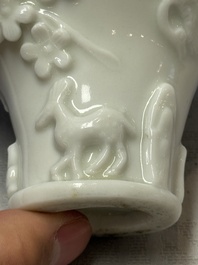 A Chinese Dehua blanc de Chine 'Dragon, Carp, Crane and Deer' libation cup, Kangxi