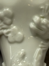 A Chinese Dehua blanc de Chine 'Dragon, Carp, Crane and Deer' libation cup, Kangxi
