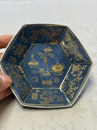 A pair of Chinese gilt-decorated powder-blue-ground 'Antiquities' cups and saucers, lingzhi mark, Kangxi