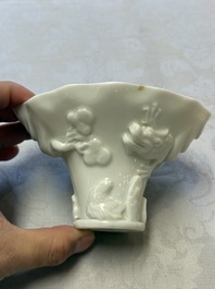 A Chinese Dehua blanc de Chine 'Dragon, Carp, Crane and Deer' libation cup, Kangxi