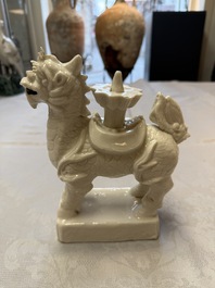 A Chinese Dehua blanc de Chine candlestick in the form a qilin, Kangxi