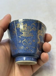 A pair of Chinese gilt-decorated powder-blue-ground 'Antiquities' cups and saucers, lingzhi mark, Kangxi