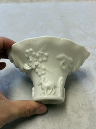 A Chinese Dehua blanc de Chine 'Dragon, Carp, Crane and Deer' libation cup, Kangxi