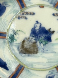 A Chinese European-decorated blue and white 'Fisherman' cup and saucer, Kangxi