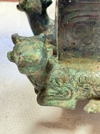 A Chinese archaic bronze cosmetic box standing on four stylised buffalo-form feet, Lian 奩, Eastern Zhou/Spring and Autumn