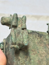 A Chinese archaic bronze cosmetic box standing on four stylised buffalo-form feet, Lian 奩, Eastern Zhou/Spring and Autumn