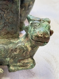 A Chinese archaic bronze cosmetic box standing on four stylised buffalo-form feet, Lian 奩, Eastern Zhou/Spring and Autumn