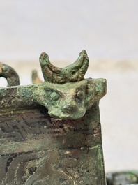 A Chinese archaic bronze cosmetic box standing on four stylised buffalo-form feet, Lian 奩, Eastern Zhou/Spring and Autumn