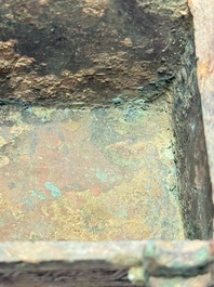 A Chinese archaic bronze cosmetic box standing on four stylised buffalo-form feet, Lian 奩, Eastern Zhou/Spring and Autumn