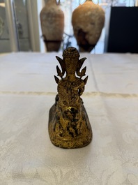 A Thai gilt-bronze figure of a seated deity with attendant animals, 19th C.