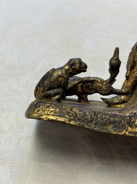 A Thai gilt-bronze figure of a seated deity with attendant animals, 19th C.