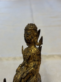 A Thai gilt-bronze figure of a seated deity with attendant animals, 19th C.