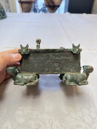 A Chinese archaic bronze cosmetic box standing on four stylised buffalo-form feet, Lian 奩, Eastern Zhou/Spring and Autumn