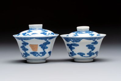 A pair of Chinese inscribed blue and white 'Clouds' tea bowls, covers and stands, Guangxu mark and of the period
