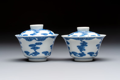 A pair of Chinese inscribed blue and white 'Clouds' tea bowls, covers and stands, Guangxu mark and of the period