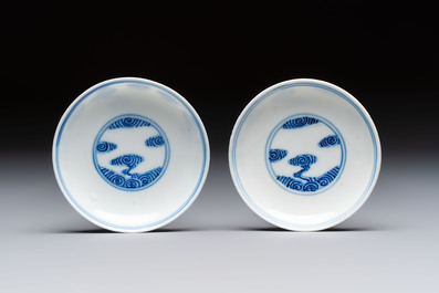 A pair of Chinese inscribed blue and white 'Clouds' tea bowls, covers and stands, Guangxu mark and of the period