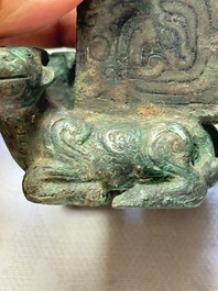 A Chinese archaic bronze cosmetic box standing on four stylised buffalo-form feet, Lian 奩, Eastern Zhou/Spring and Autumn