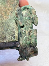 A Chinese archaic bronze cosmetic box standing on four stylised buffalo-form feet, Lian 奩, Eastern Zhou/Spring and Autumn
