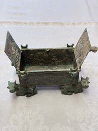 A Chinese archaic bronze cosmetic box standing on four stylised buffalo-form feet, Lian 奩, Eastern Zhou/Spring and Autumn