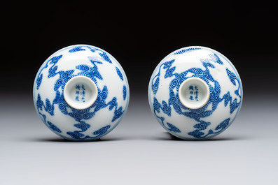 A pair of Chinese inscribed blue and white 'Clouds' tea bowls, covers and stands, Guangxu mark and of the period