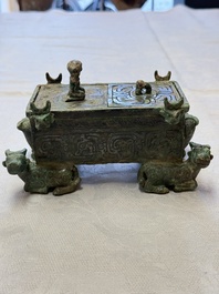 A Chinese archaic bronze cosmetic box standing on four stylised buffalo-form feet, Lian 奩, Eastern Zhou/Spring and Autumn