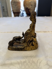 A Thai gilt-bronze figure of a seated deity with attendant animals, 19th C.