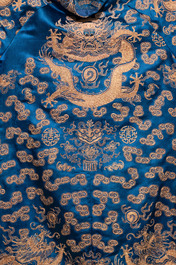 A Chinese embroidered silk blue-ground 'Dragons' robe, adapted into a lady's dress, 19th C. and later